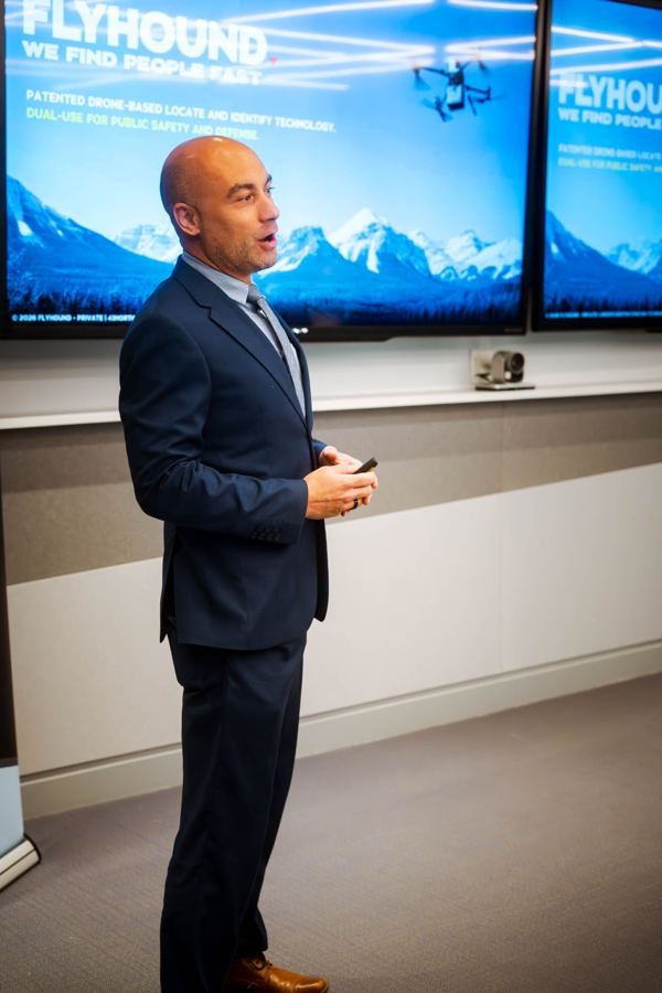 Manny presenting Flyhound in front of large screens